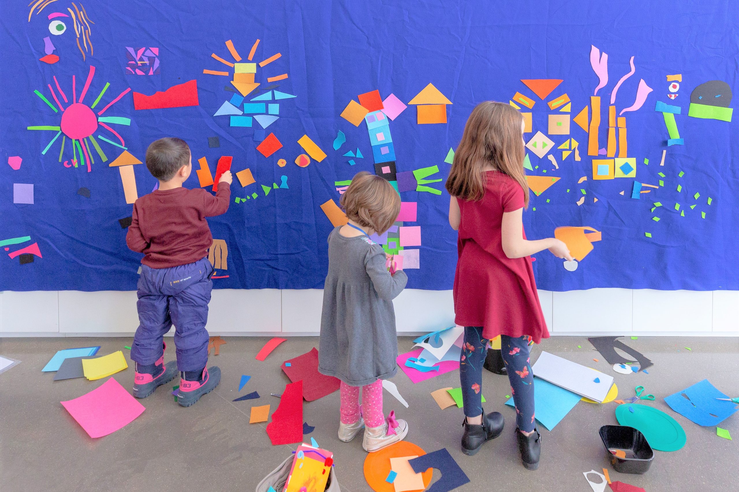 Three kids work on an art project together at Family Day.