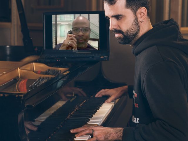 Photo of Albert Marquès playing the piano and Keith LaMar performing poetry.