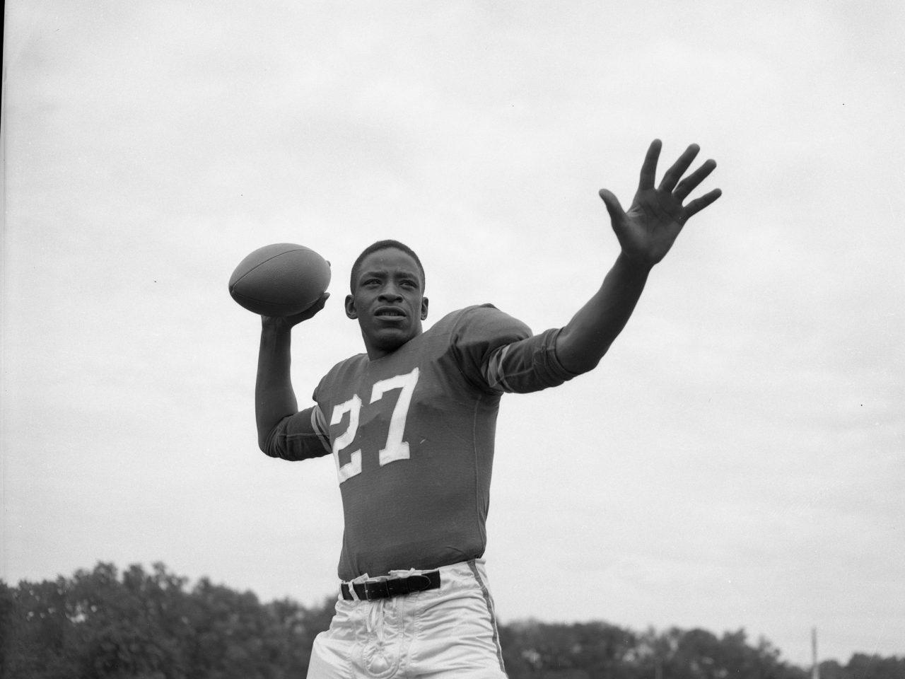 Black and white photo of man throwing a football