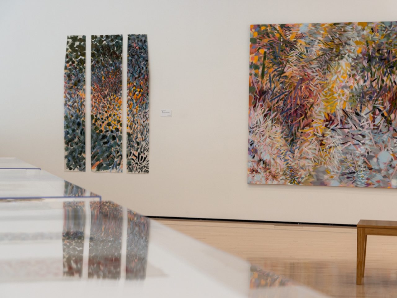 Three long and thin paintings to the left of large abstract painting