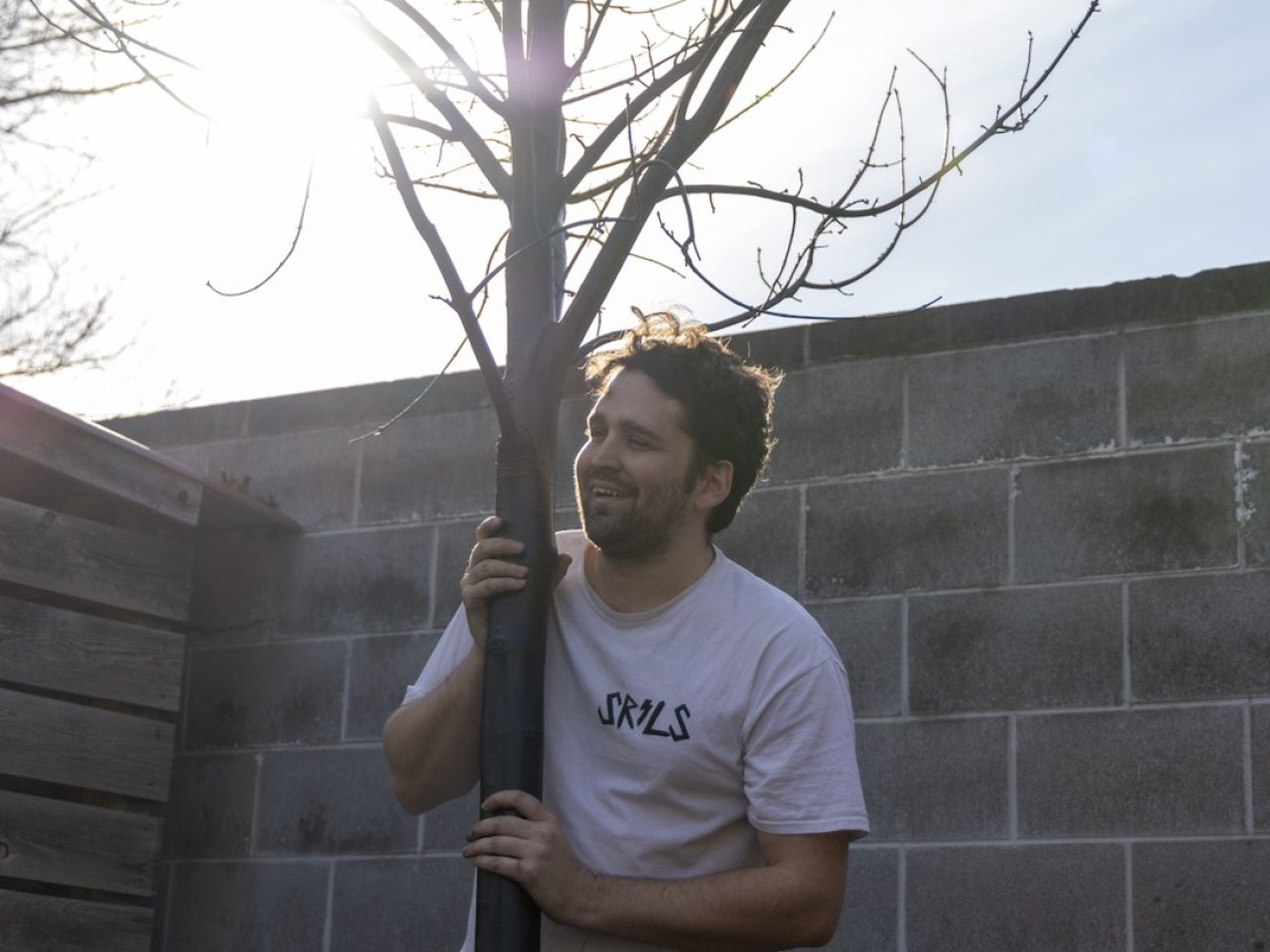 Photo of Patrick Taylor holding a tree