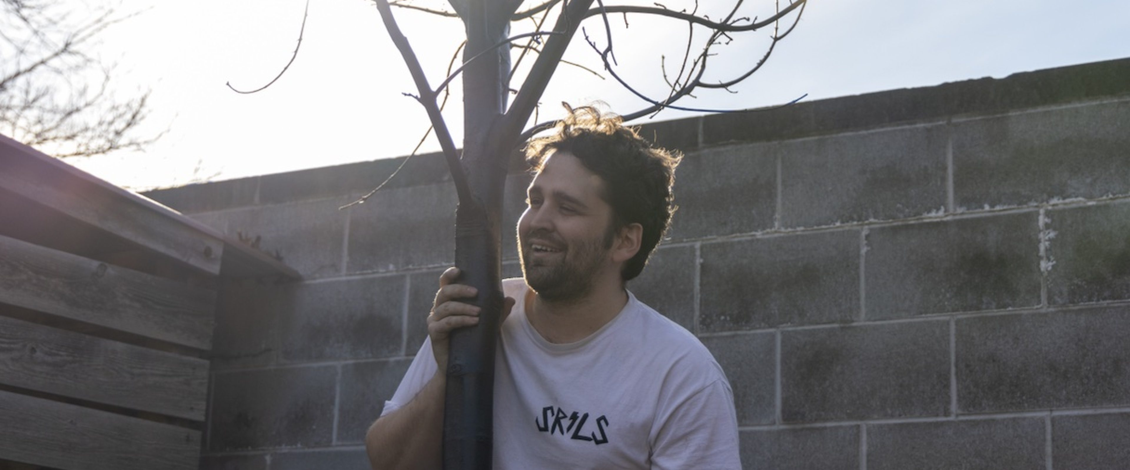 Photo of Patrick Taylor holding a tree