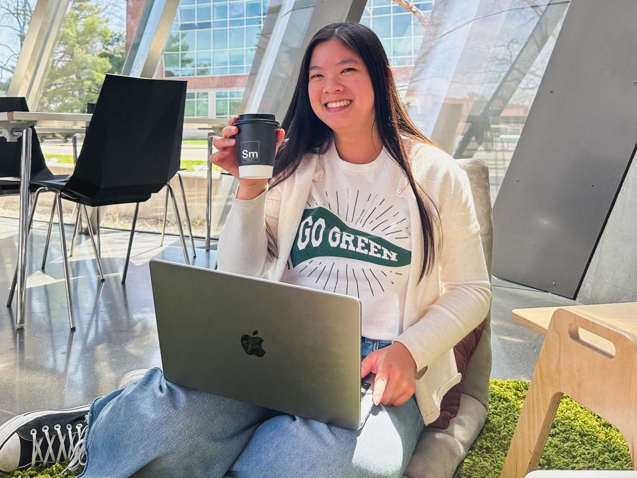 Person studying holding up cup of coffee