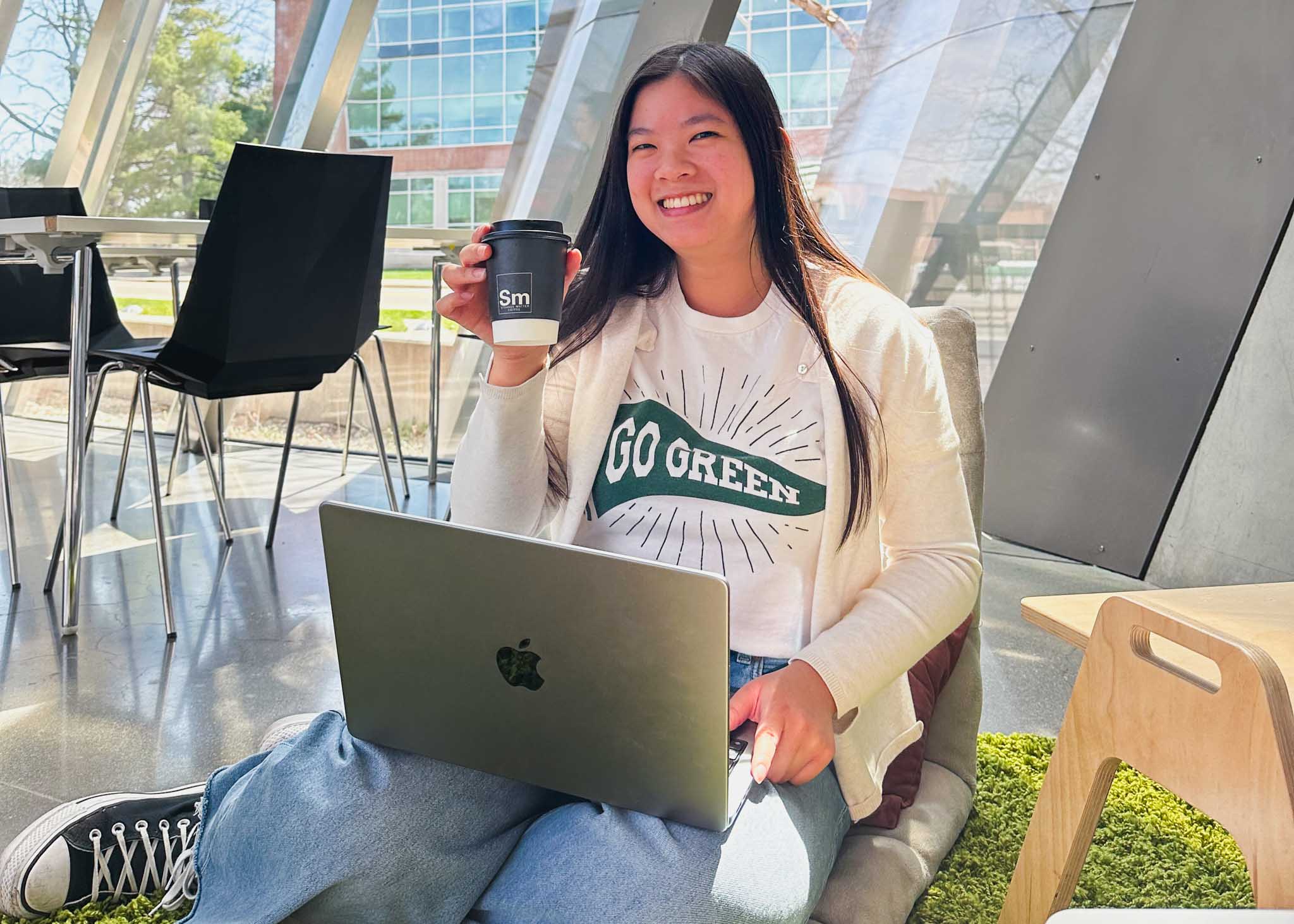 Person studying holding up cup of coffee