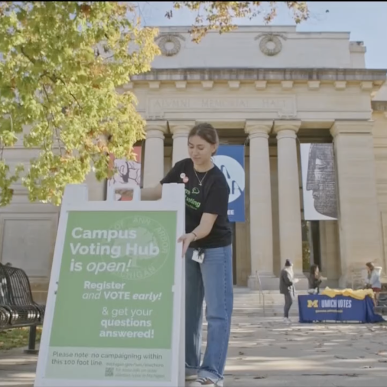 girl setting up a voting sign